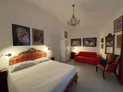 a bedroom with a large bed and a red couch at House of Cardinals in Rome