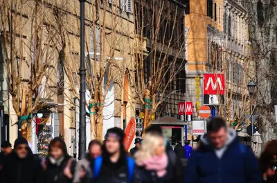 a group of people walking down a city street at House of Cardinals in Rome