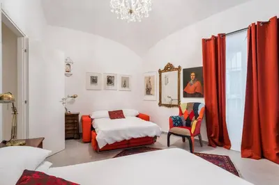 a bedroom with two beds and red curtains at House of Cardinals in Rome
