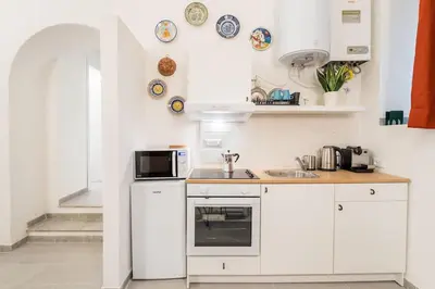 a white kitchen with a sink and a microwave at House of Cardinals in Rome