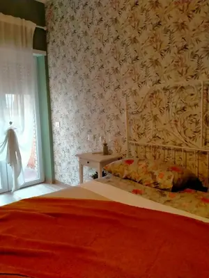 a bedroom with a bed and a wall with floral wallpaper at The green place alloggio turistico in Rome