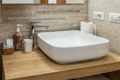 a bathroom with a white sink on a wooden counter at Domus Dino in Rome
