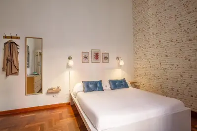 a bedroom with a white bed with two blue pillows at B5 Apartment Vatican in Rome