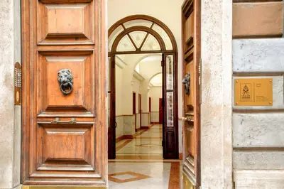 a wooden door with a lion head on it in a hallway at B5 Apartment Vatican in Rome