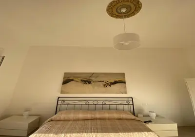 a bedroom with a bed and a painting on the wall at Dew Vatican Apartment in Rome