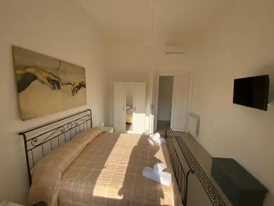 a bedroom with a bed and a flat screen tv at Dew Vatican Apartment in Rome