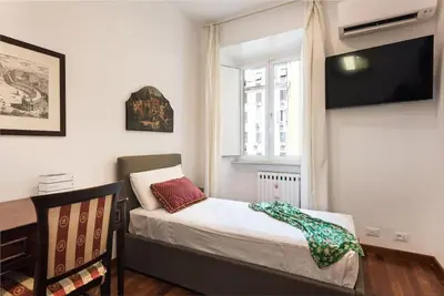 a small bedroom with a bed and a window at Idyllia - Classy apartment in Vatican area in Rome