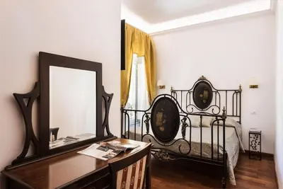 a bedroom with a bed and a mirror and a dresser at Idyllia - Classy apartment in Vatican area in Rome