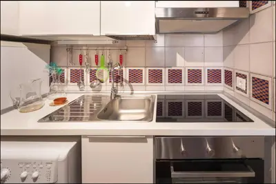 a white kitchen with a sink and a stove at Accogliente casa al Pantheon in Rome