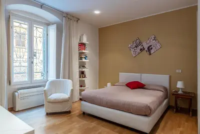 a bedroom with a bed and a chair and a window at GuestHost - Suite dell'Emporio in Rome
