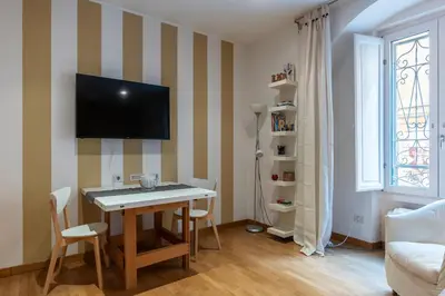 a living room with a table and a tv on a wall at GuestHost - Suite dell'Emporio in Rome