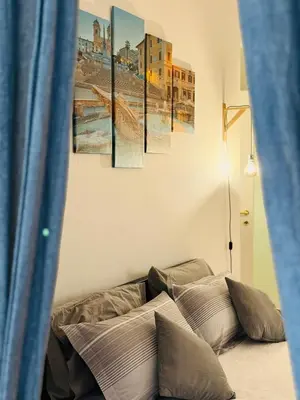 a bed in a room with four paintings on the wall at La Cornice Apartment in Rome