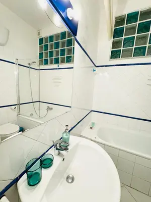 a white bathroom with a sink and a bath tub at La Cornice Apartment in Rome