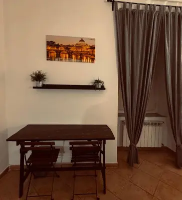 a dining room table with chairs and a picture on the wall at La Cornice Apartment in Rome