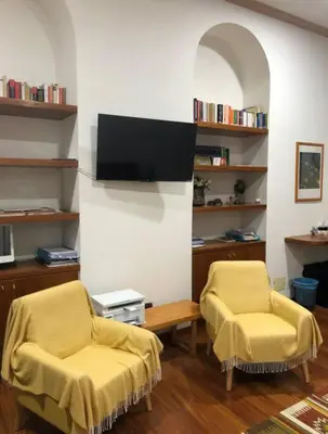 a living room with two chairs and a tv at Loft Accogliente - Piazza San Giovanni in Rome