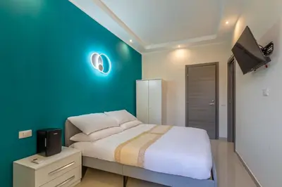 a bedroom with a bed with a blue wall at Hyper Lodge Termini GuestHouse in Rome