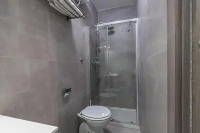 a bathroom with a toilet and a glass shower at Hyper Lodge Termini GuestHouse in Rome