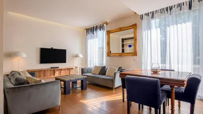 a living room with a table and a television at [ROMAN JEWEL] Elegant apartment near the center in Rome