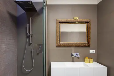 a bathroom with a shower with a sink and a mirror at [ROMAN JEWEL] Elegant apartment near the center in Rome