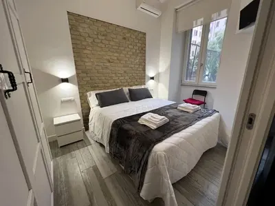 a bedroom with a bed and a brick wall at Modern Apartment near the Vatican in Rome
