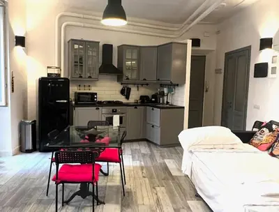 a kitchen and a living room with a table and chairs at Modern Apartment near the Vatican in Rome
