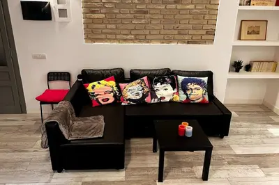 a black couch with pillows on it in a living room at Modern Apartment near the Vatican in Rome