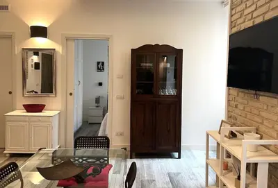 a living room with a glass table and a cabinet at Modern Apartment near the Vatican in Rome