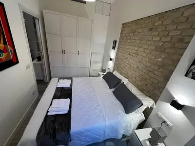 a bedroom with a large bed and a brick wall at Modern Apartment near the Vatican in Rome