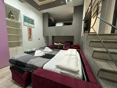 a bedroom with a large bed and a staircase at Ponte Milvio Lovely Studio in Rome