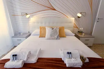 a bedroom with a large white bed with two towels at Elide - Nido d'amore in Ponte Milvio con Balcone in Rome