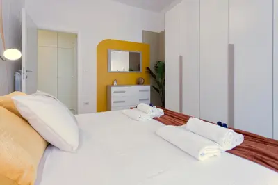 a bedroom with a white bed with two towels at Elide - Nido d'amore in Ponte Milvio con Balcone in Rome