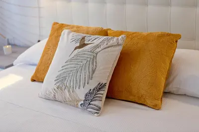 a bed with two pillows and a bird on it at Elide - Nido d'amore in Ponte Milvio con Balcone in Rome