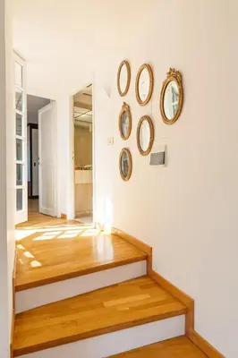 a hallway with wooden floors and clocks on the wall at Piede Charming Apartment in Rome