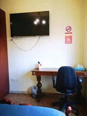 a desk with a television on a wall with a chair at stazione trastevere\u516c\u5bd3 in Rome