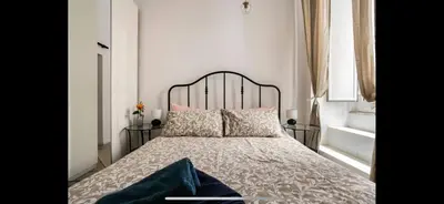 a bedroom with a bed with a black headboard and pillows at Leonidas’s House in Rome