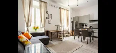 a living room with a couch and a table and a kitchen at Leonidas’s House in Rome