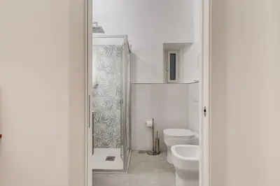 a white bathroom with a toilet and a sink at MONTI44 Boutique Apartment in Rome