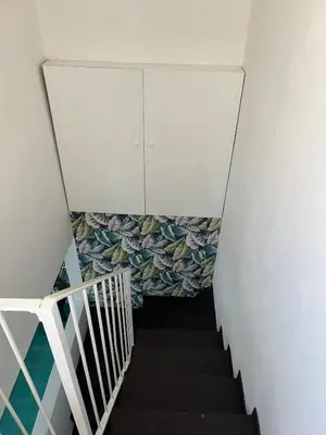 a stairway with a white wall and a white cabinet at Loft Panoramico San Giovanni in Rome