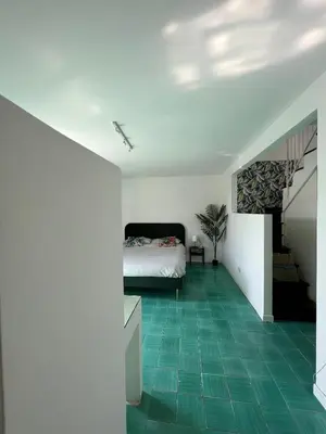 a bedroom with a bed and a green tile floor at Loft Panoramico San Giovanni in Rome