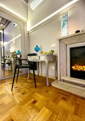 a living room with a fireplace and a table and chairs at Z-ArchSuites Urbs in Rome