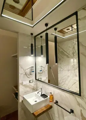 a bathroom with a sink and a mirror at Z-ArchSuites Urbs in Rome
