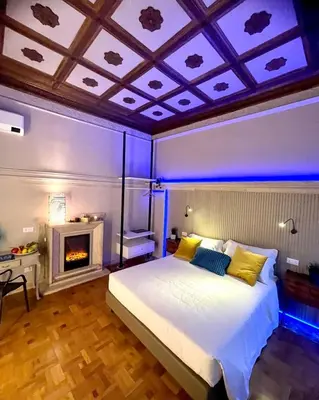 a bedroom with a large bed and a fireplace at Z-ArchSuites Urbs in Rome