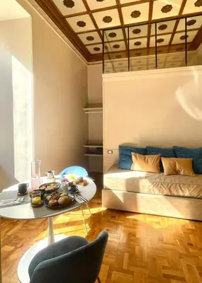 a living room with a bed and a table and a couch at Z-ArchSuites Urbs in Rome