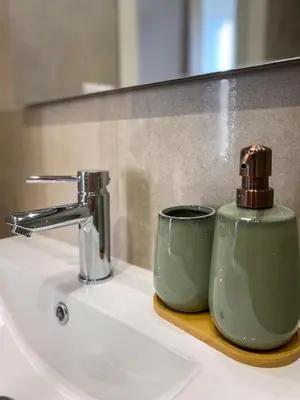 a green mug sitting on a bathroom sink at Boho Suites - Rome Colosseum in Rome