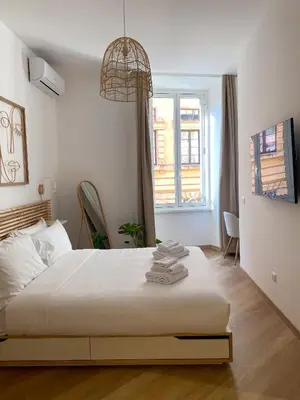 a bedroom with a white bed and a window at Boho Suites - Rome Colosseum in Rome