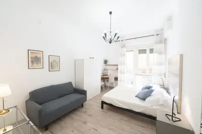 a bedroom with a bed and a chair at Lovely Apartment in Hip and Vibrant Pigneto in Rome
