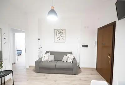a living room with a gray couch in a white room at Lovely Apartment in Hip and Vibrant Pigneto in Rome