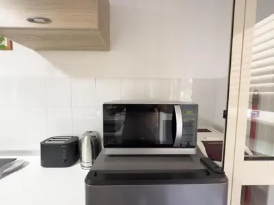 a microwave sitting on top of a refrigerator in a kitchen at Lovely Apartment in Hip and Vibrant Pigneto in Rome