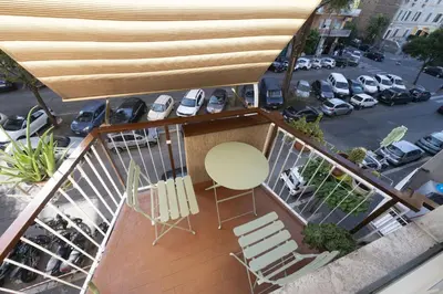 a balcony with chairs and a table and a parking lot at Lovely Apartment in Hip and Vibrant Pigneto in Rome