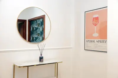 a mirror on a wall next to a table at Real Vatican Inn in Rome